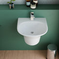 Glossy white ceramic wall hung sink with integrated shroud underside, compact rounded-rectangle shape