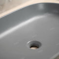 Rectangular sink bowl drain opening detail, matte gray ceramic vessel sink for counter top basins