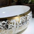 Vessel sink in bathroom vanity setup, modern sink above counter in glossy white with gold accent