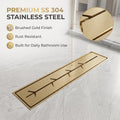 Slim brushed gold shower drain grate for a tiled bathroom floor