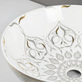 Ceramic vessel sink drain opening detail, glossy white round above counter sink with gold edge
