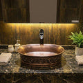 Angled view of modern sink, matte copper ceramic oval vessel sink for vanity countertop for vessel sink