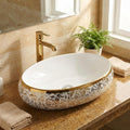 Bath vessel sink close-up of glossy white ceramic finish and gold rim detail, oval shape