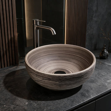 Natural oak brown round ceramic vessel sink installed on a dark bathroom vanity