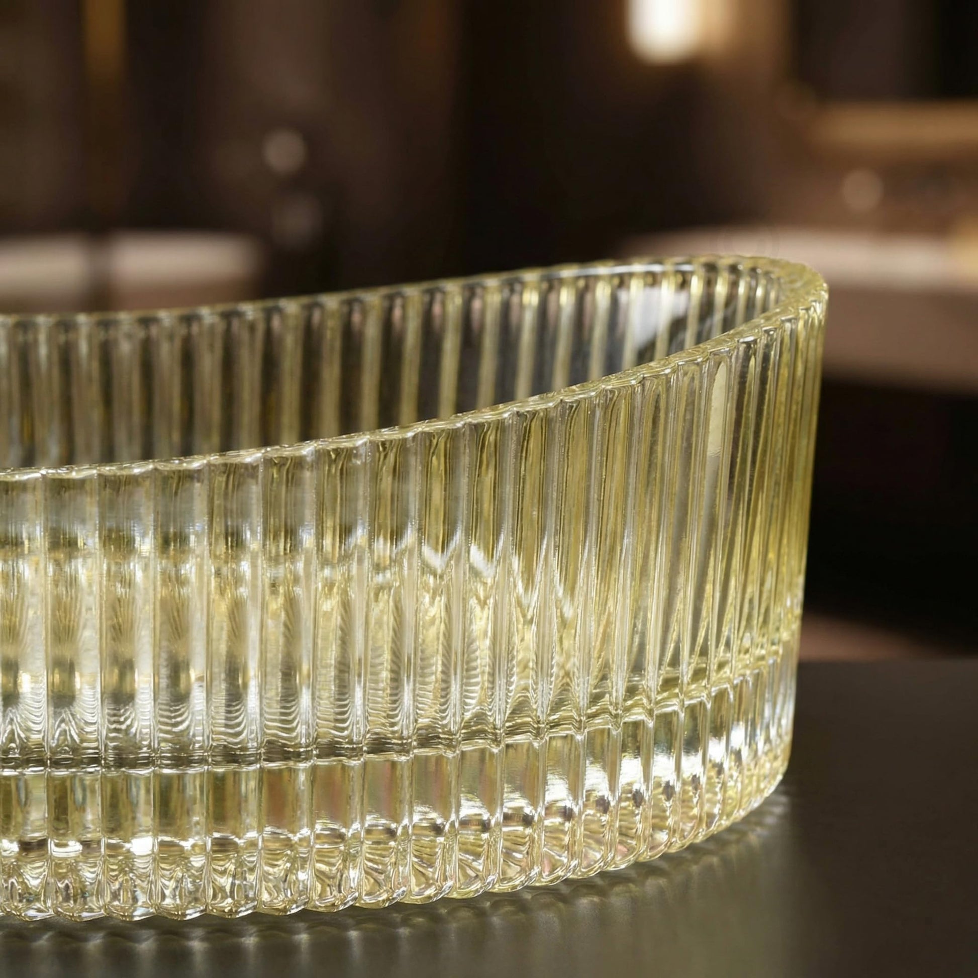 Lifestyle modern vessel sink vanity setup with gold glass vessel sink, oval countertop basin and gold faucet