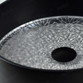 Designer round vessel sink on vanity, matte black glass bowl showing clear patterned textured base detail